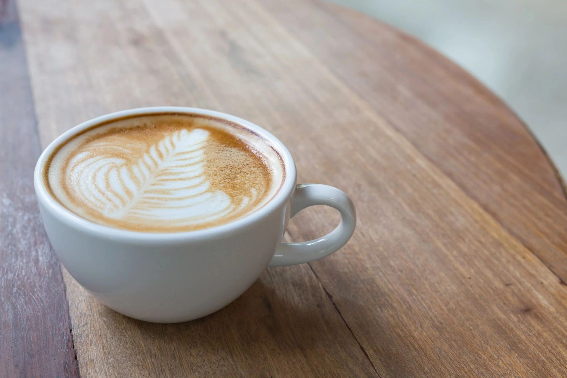 Latte on a wooden table from the Hangar 31 Cafe source site
